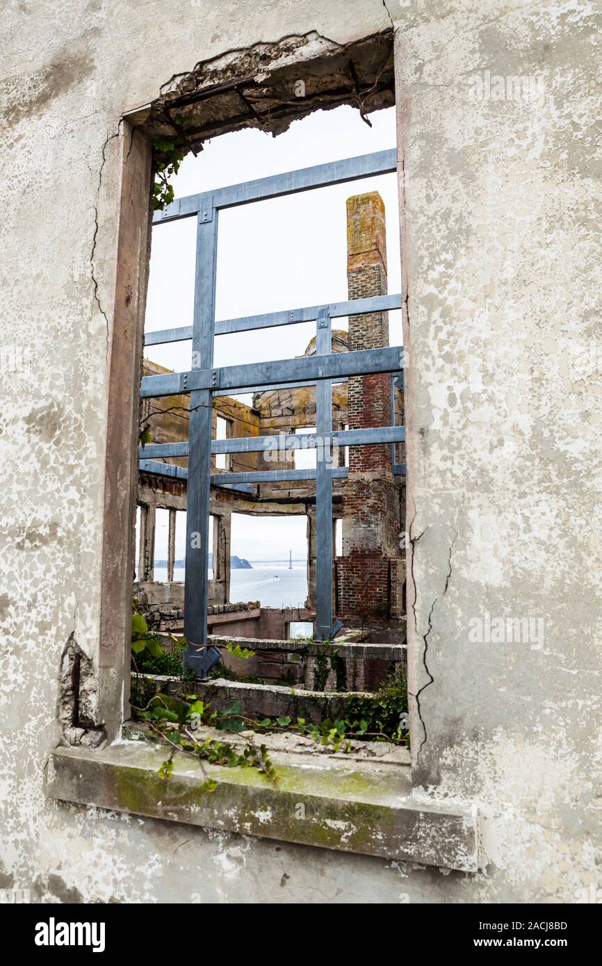 Durch ein Fenster in einem alten verwitterten Gebäude auf Alcatraz Island/Gefängnis sehen durch das Gebäude an die Bucht und die Bay Bridge, Ca Stockfoto