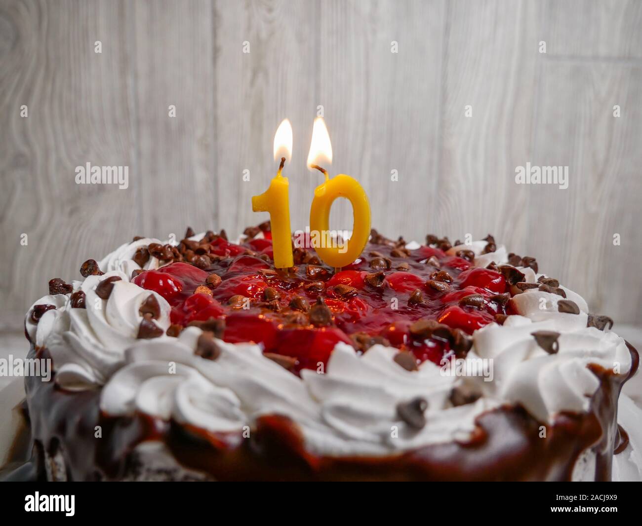 10 Kerze Anzahl leuchtet auf einem Schokoladen Kirschtorte Stockfoto