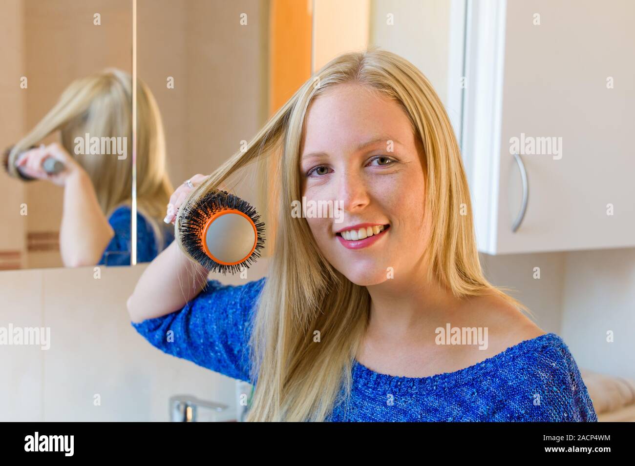 Frau Bürsten ihr Haar Stockfoto