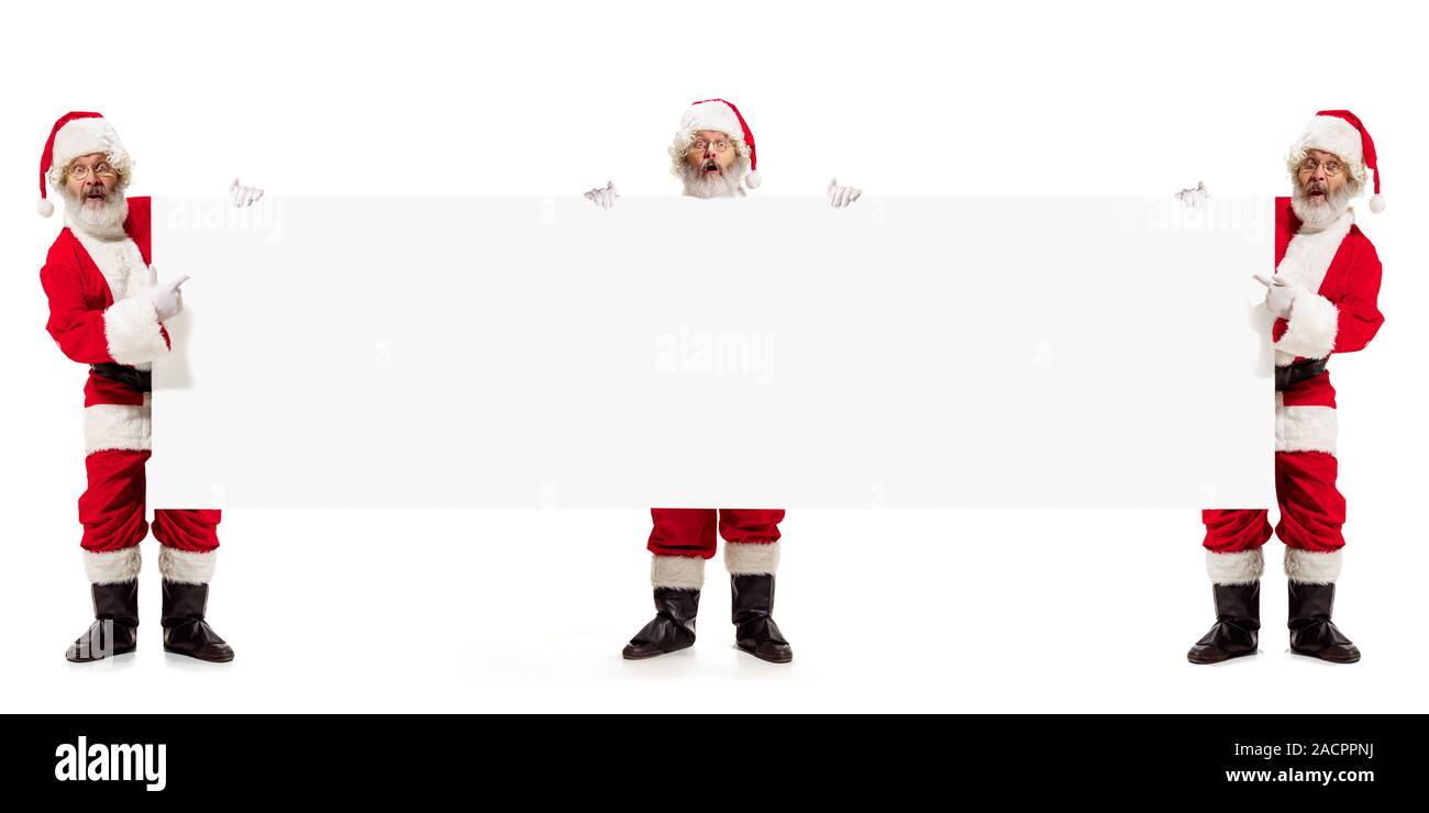Emotionale Santa Claus Gruß mit Neuen Jahr 2020 und Weihnachten. Männer in Tracht mit großen weißen Blatt für Ihre Werbung. Winter, Ferien Stimmung, Geschenke, wünschte. Copyspace. Stockfoto