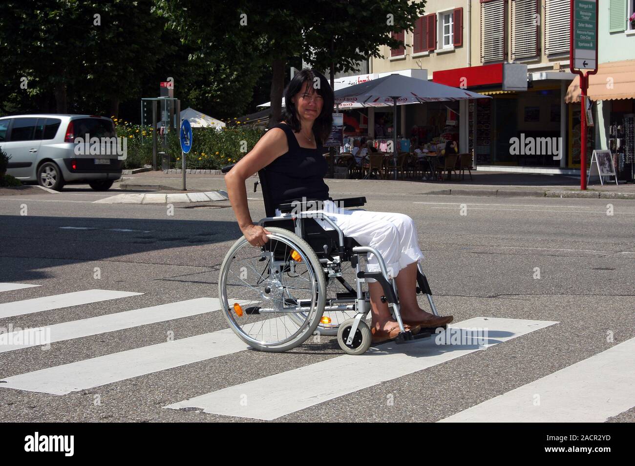 Behinderte Frau in einem Rollstuhl, Alltag in der Stadt Stockfoto