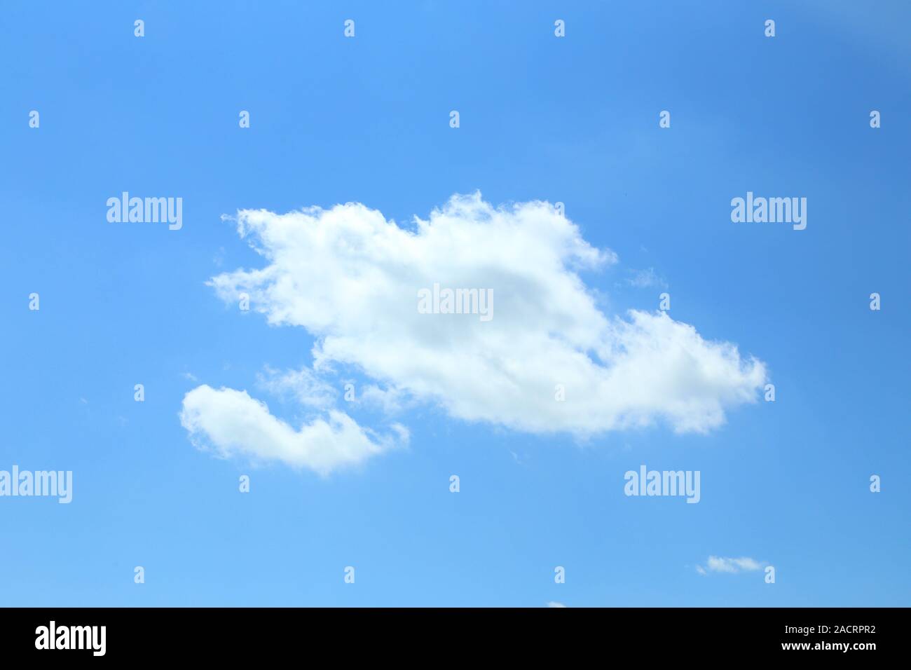 Einzelne Kumuluswolke auf einem blauen Himmel Stockfoto