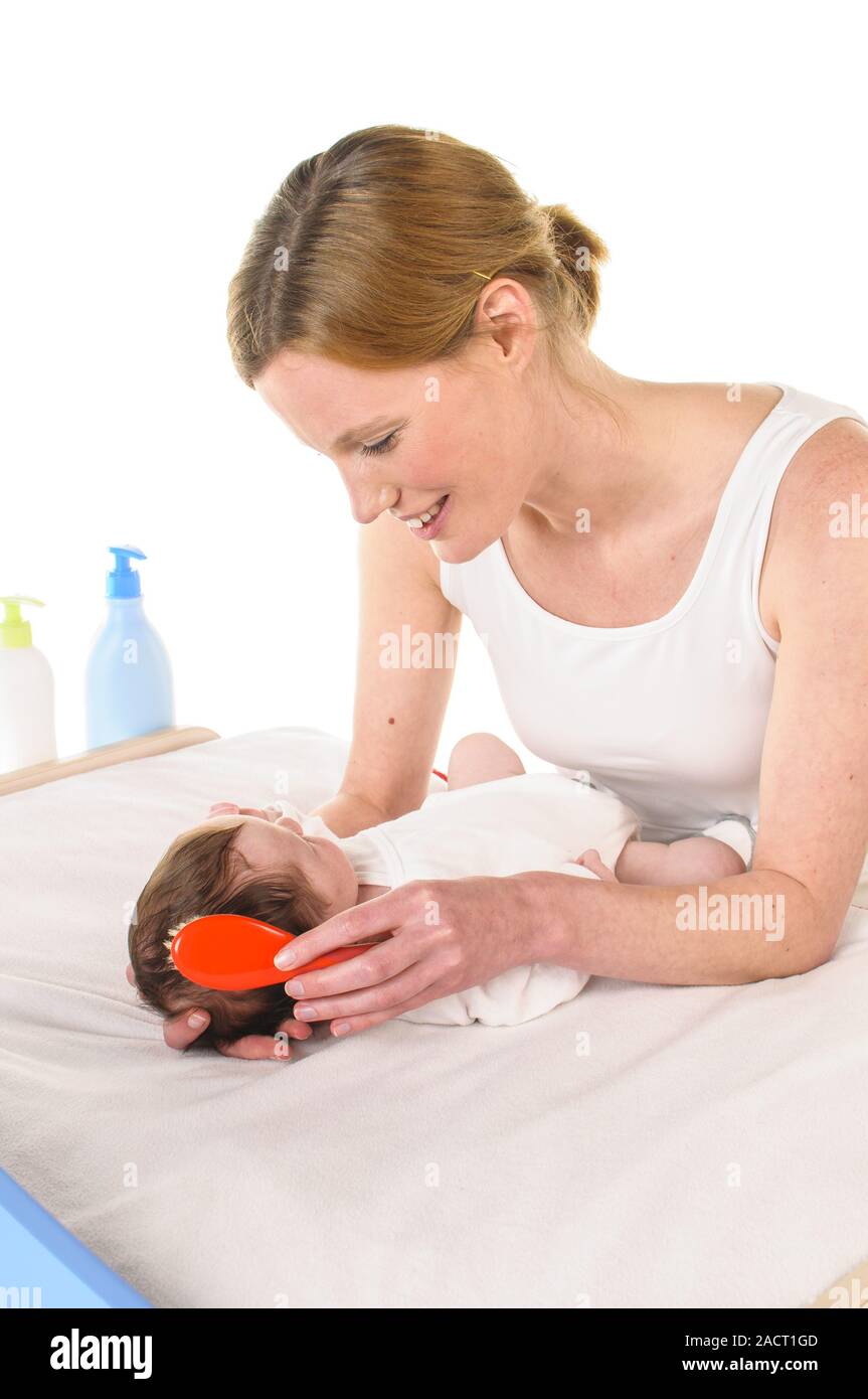 Mutter mit Baby- und Haarbürsten Stockfoto