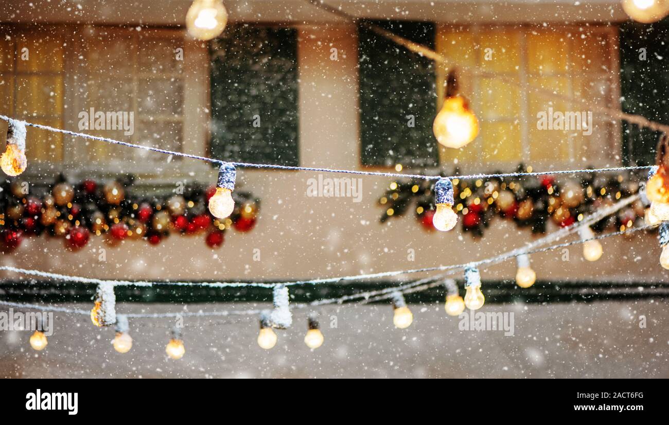 Girlanden der Lampen auf der Straße mit Weihnachten Dekoration bei Schneewetter. Stockfoto