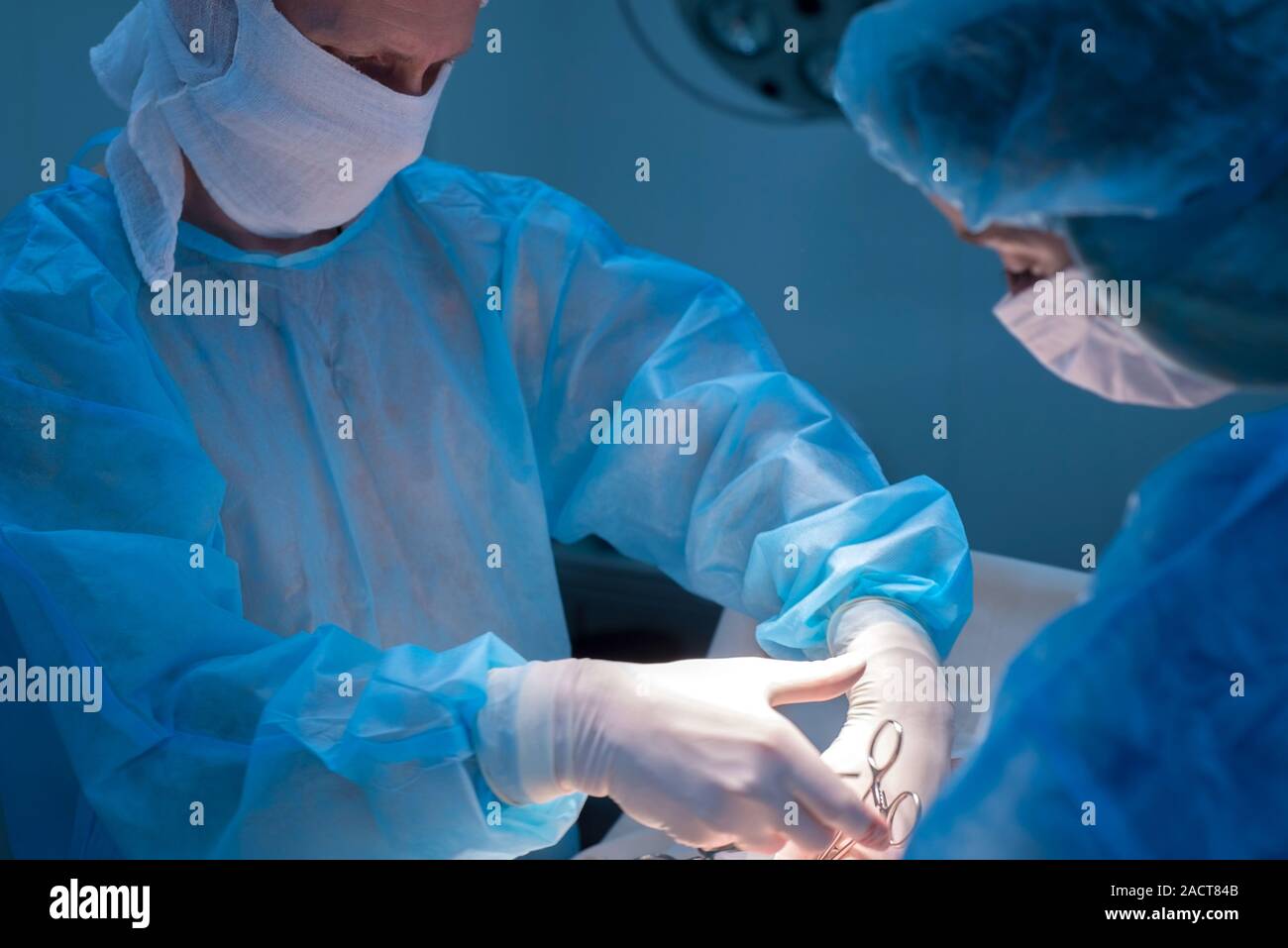 Chirurgen Kinder urologische Operationen durchführen. Ein Mann und eine Frau in einer Maske und einem blauen sterile Mantel in den Operationssaal. Ein Team von Chirurgen ist Co Stockfoto