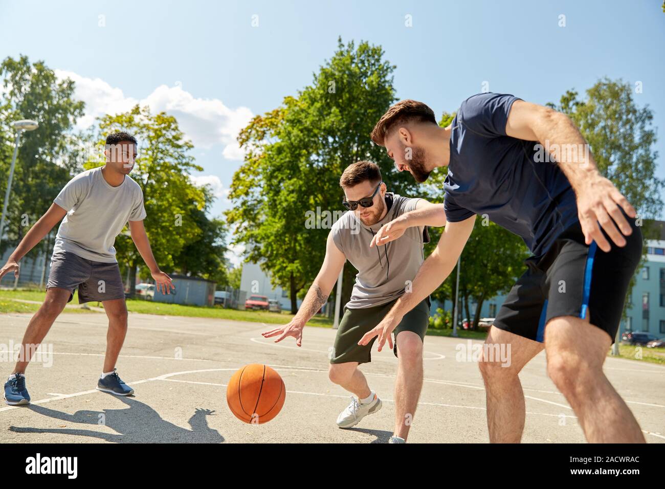 Sport, Freizeit Spiele und männliche Freundschaft Konzept - Gruppe der Männer oder Freunde spielen street Basketball Stockfoto
