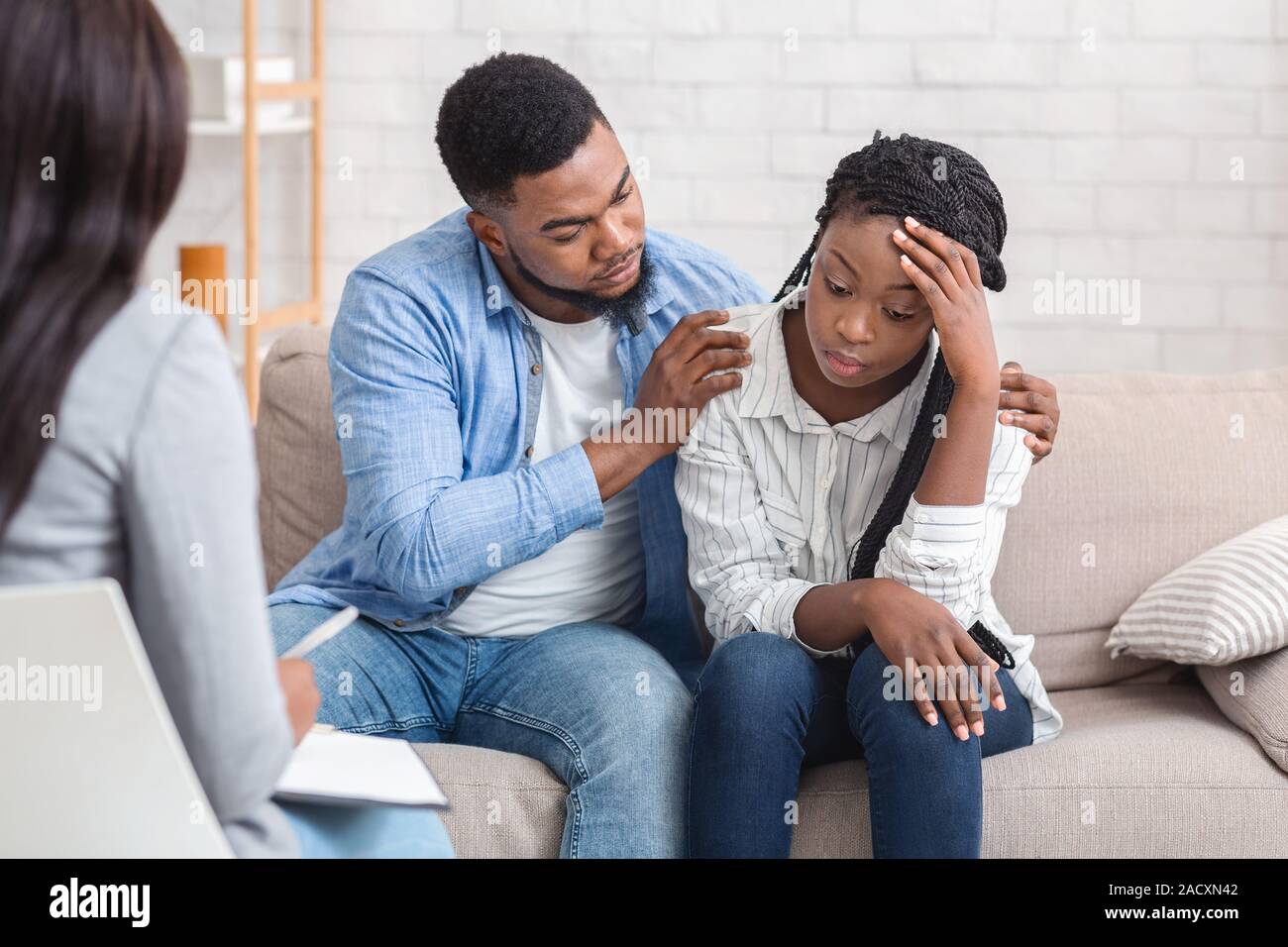 Liebevoller Ehemann seiner depressiven Frau Unterstützung während der Psychotherapie Sitzung mit Ratgeber Stockfoto