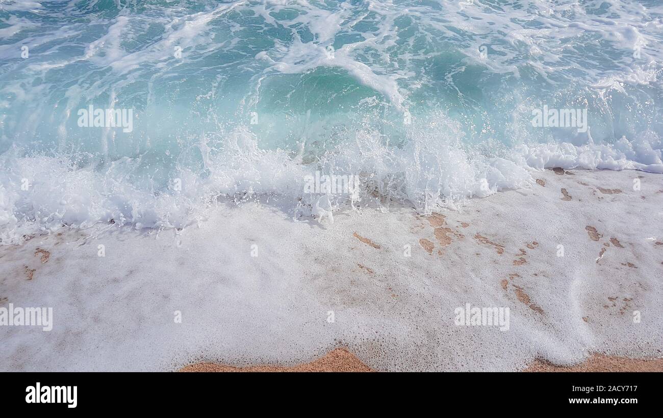Zusammenfassung Hintergrund der Wellen im Meer, auf goldenen Sand, Weißes Meer Schaum. Stockfoto