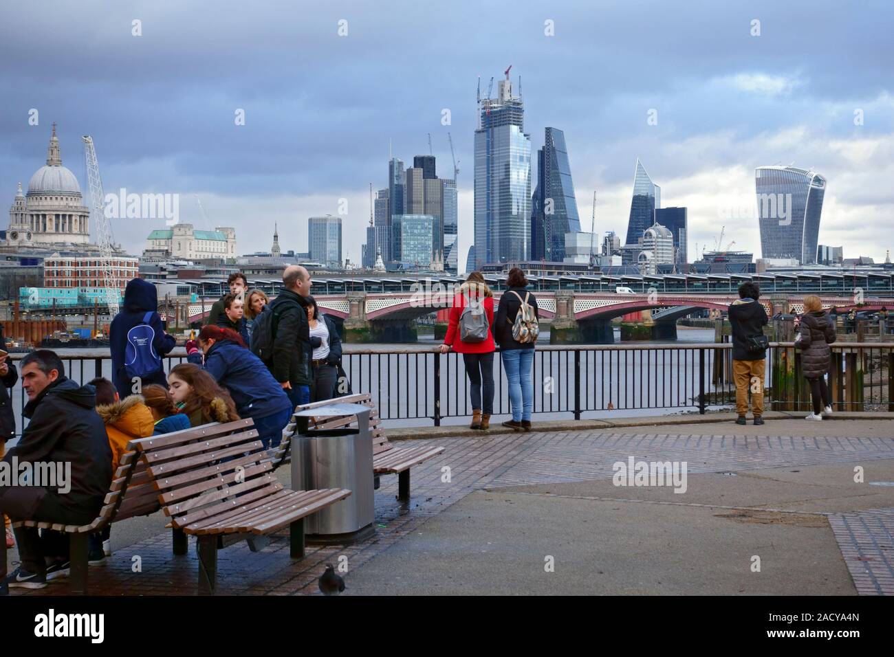 Die Leute an der Skyline von London und seinen ikonischen Gebäude am Nordufer der Themse von der South Bank suchen. Stockfoto