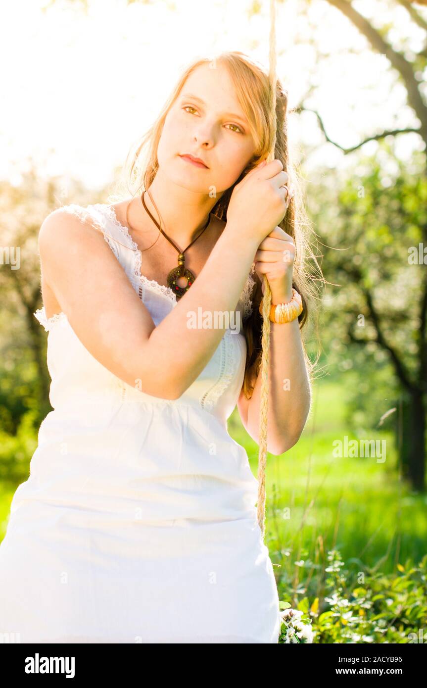 Junge Frau Schaukeln im Cherry Orchard Stockfoto