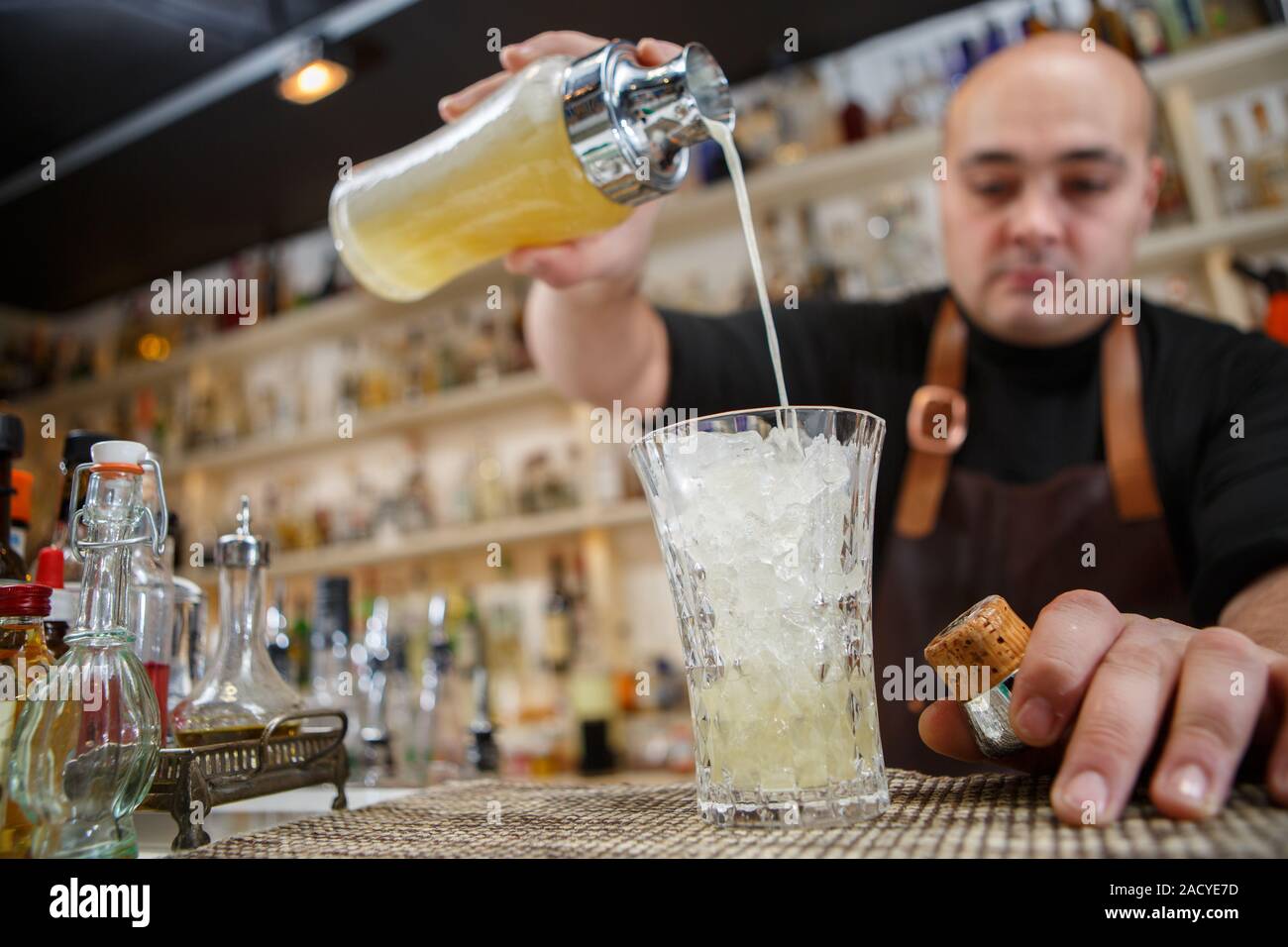 Barkeeper in Glas an der Bar cocktail gießen Stockfoto