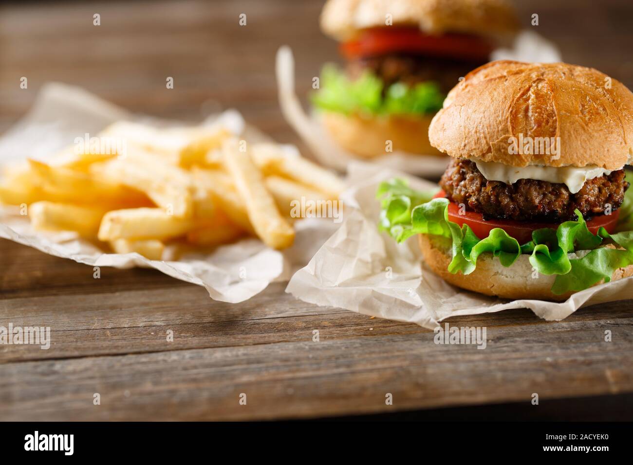 Hausgemachte leckere Burger und Pommes Frites auf Holztisch Stockfoto