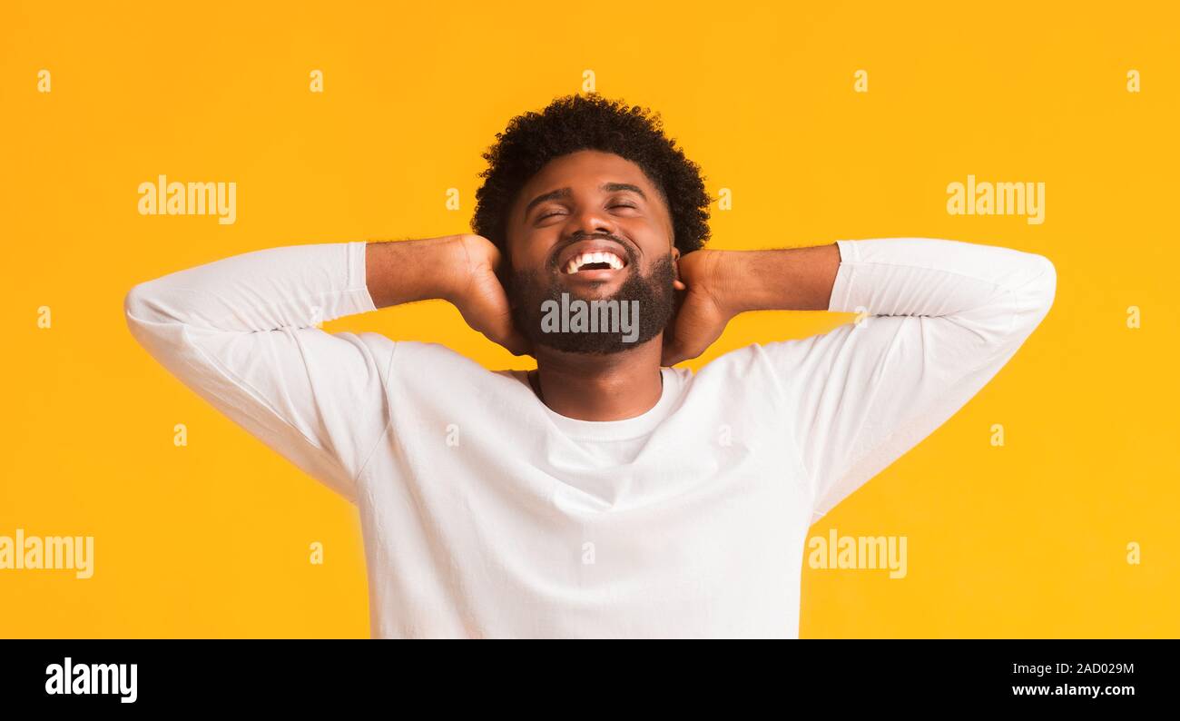Sorglos afro Kerl lehnte sich auf seinen Händen Stockfoto