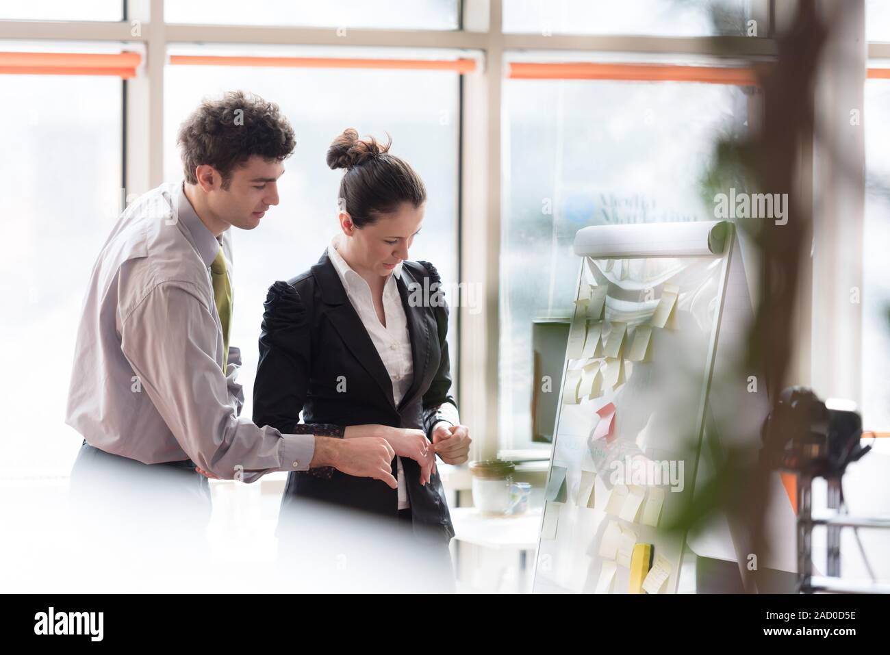 Junges Paar arbeiten auf Flip Board im Büro Stockfoto
