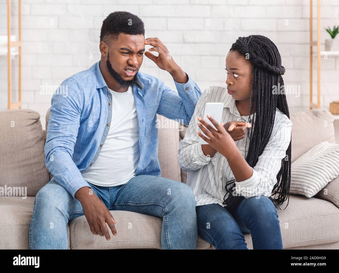 Wütend Afro Freundin zeigt Ihre betrügenden Freund sein Handy, anspruchsvolle Erläuterung Stockfoto