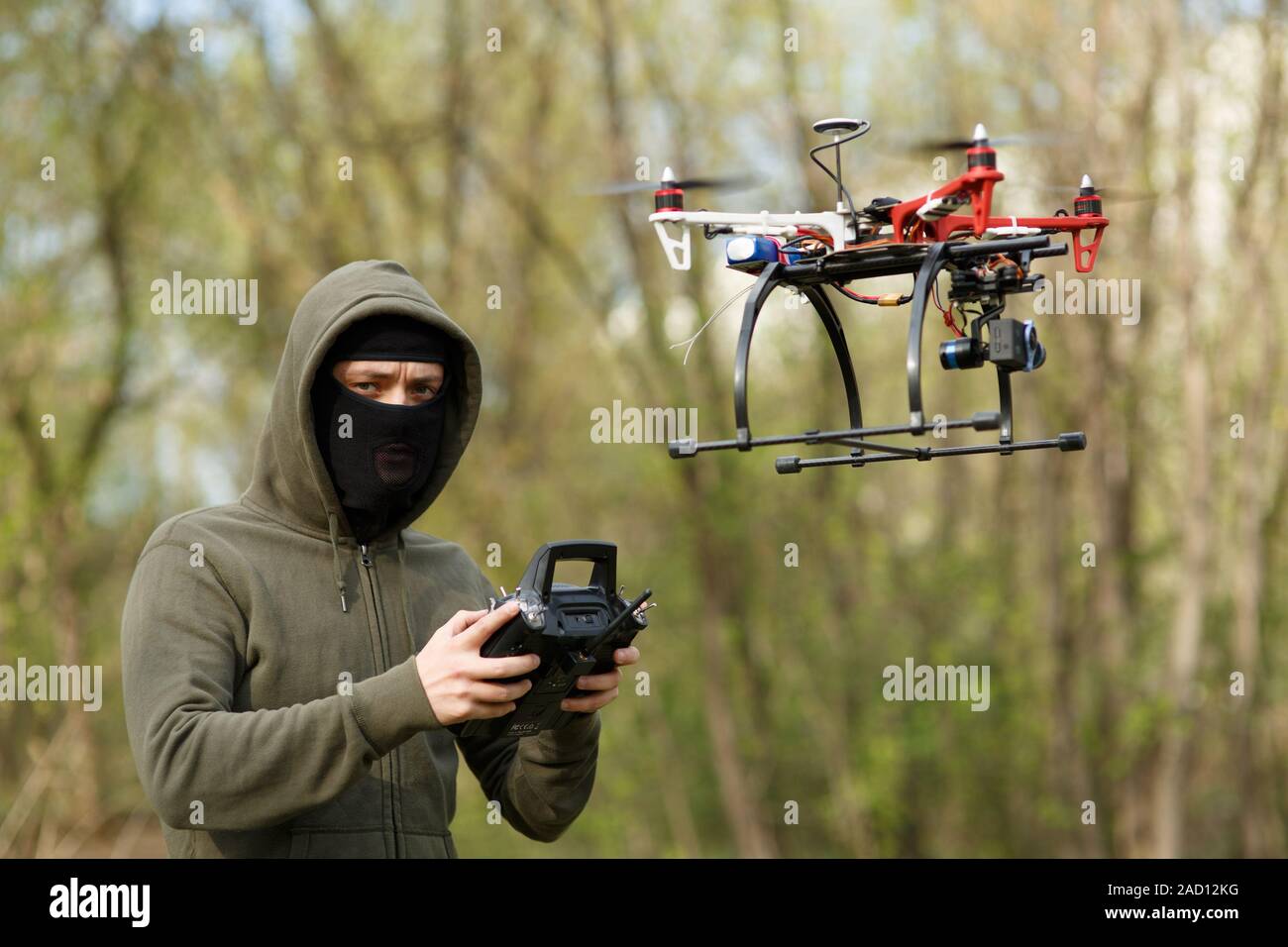 Mann mit Maske, die eine Drohne mit Fernbedienung in Betrieb. Stockfoto