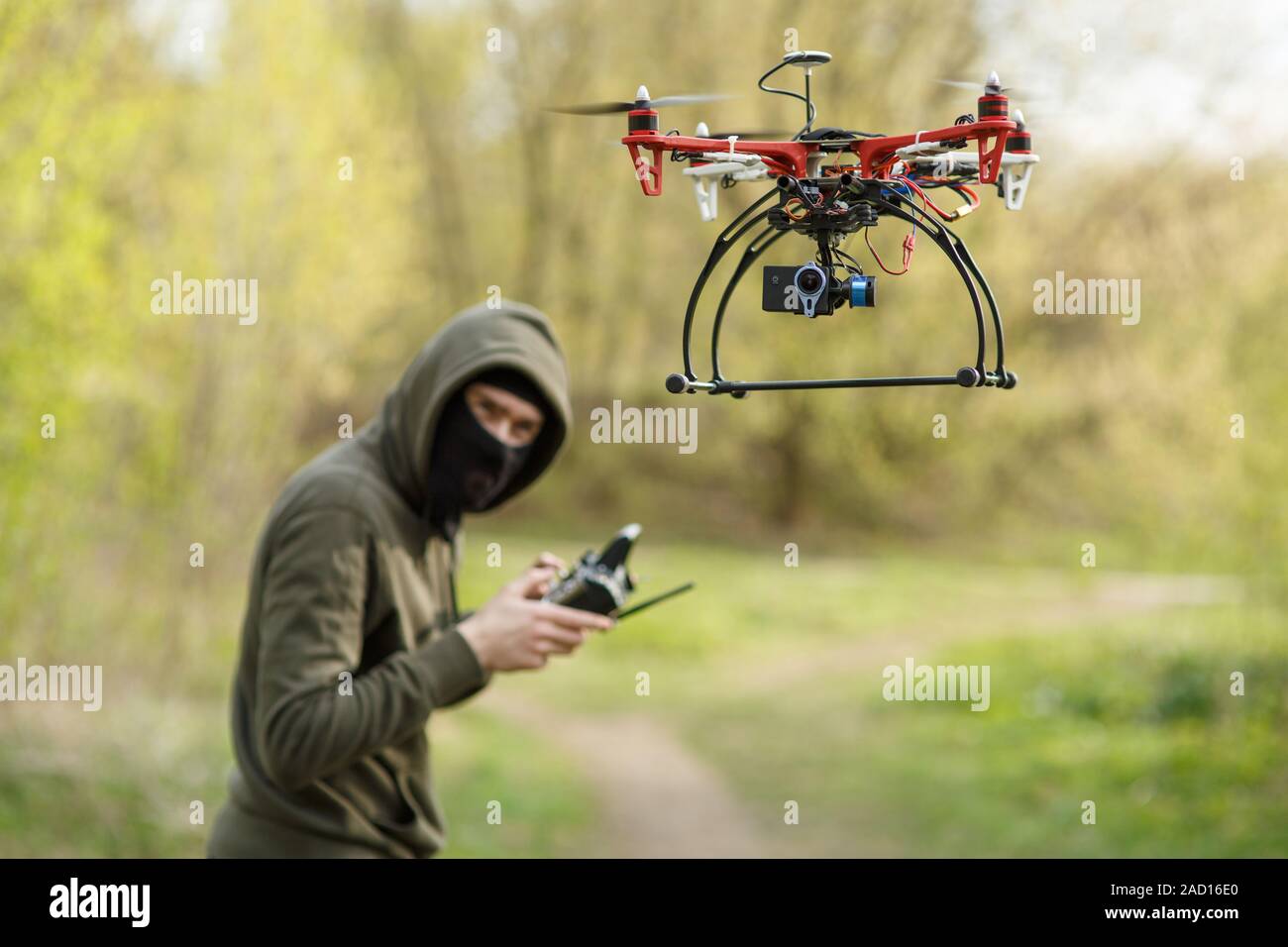 Mann mit Maske, die eine Drohne mit Fernbedienung in Betrieb. Stockfoto