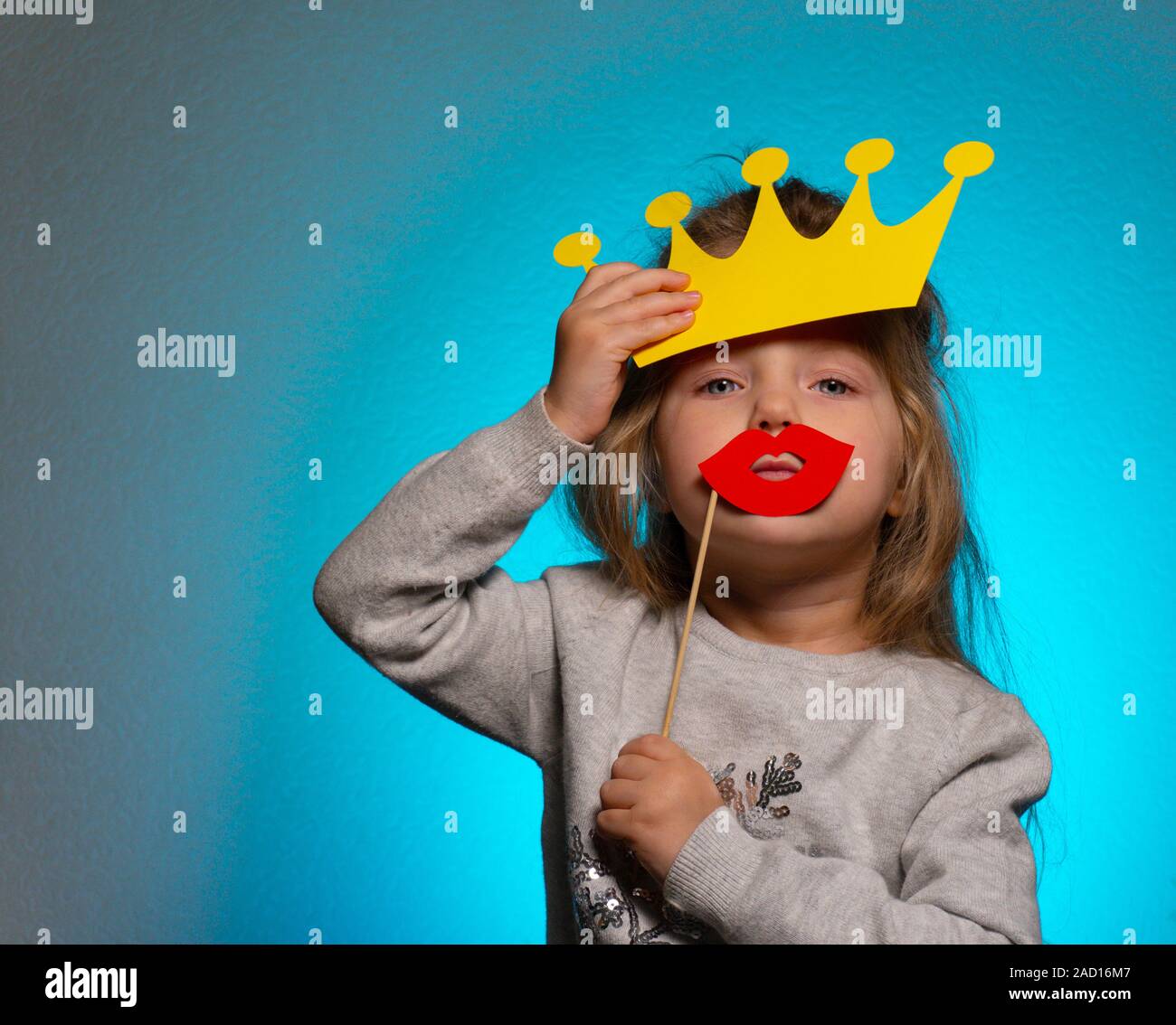 Kleine lustige Königin mit gelber Krone und roten Lippen Stockfoto