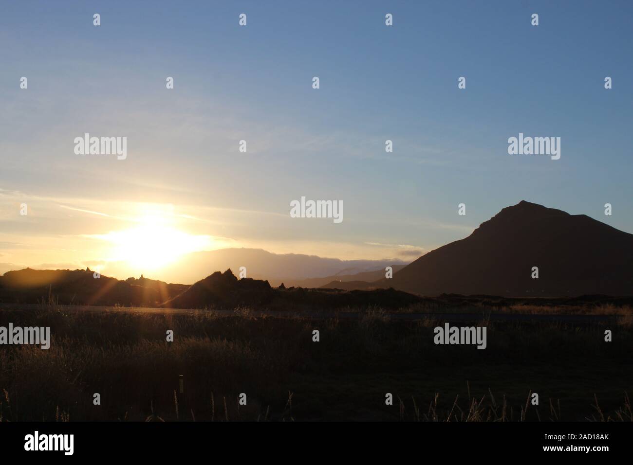 Orange Sonnenuntergang hinter einem Berg in Island Stockfoto