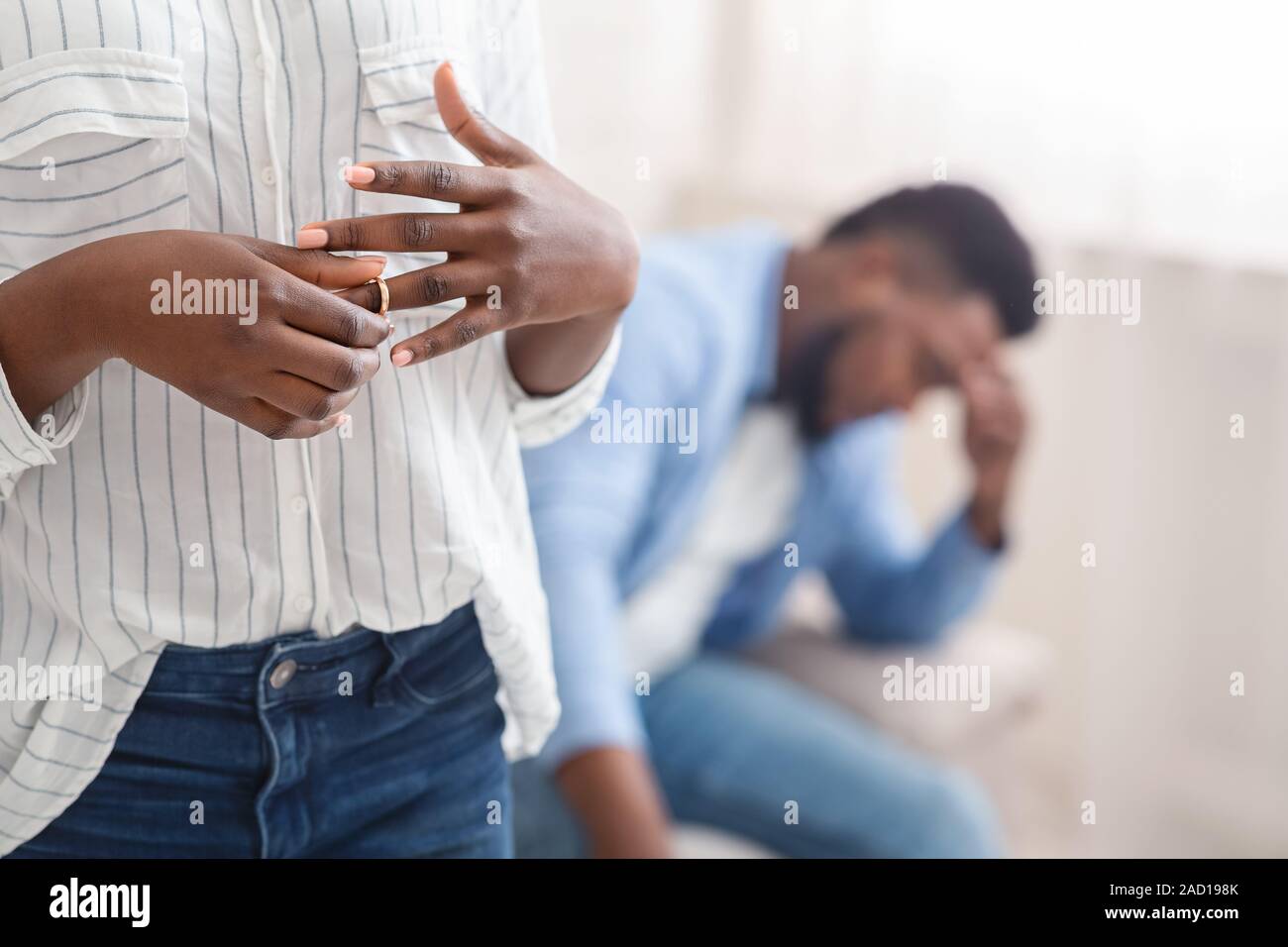 Nicht erkennbare schwarze Frau entfernen Ehering vom Finger, scheiden mit Ehemann Stockfoto