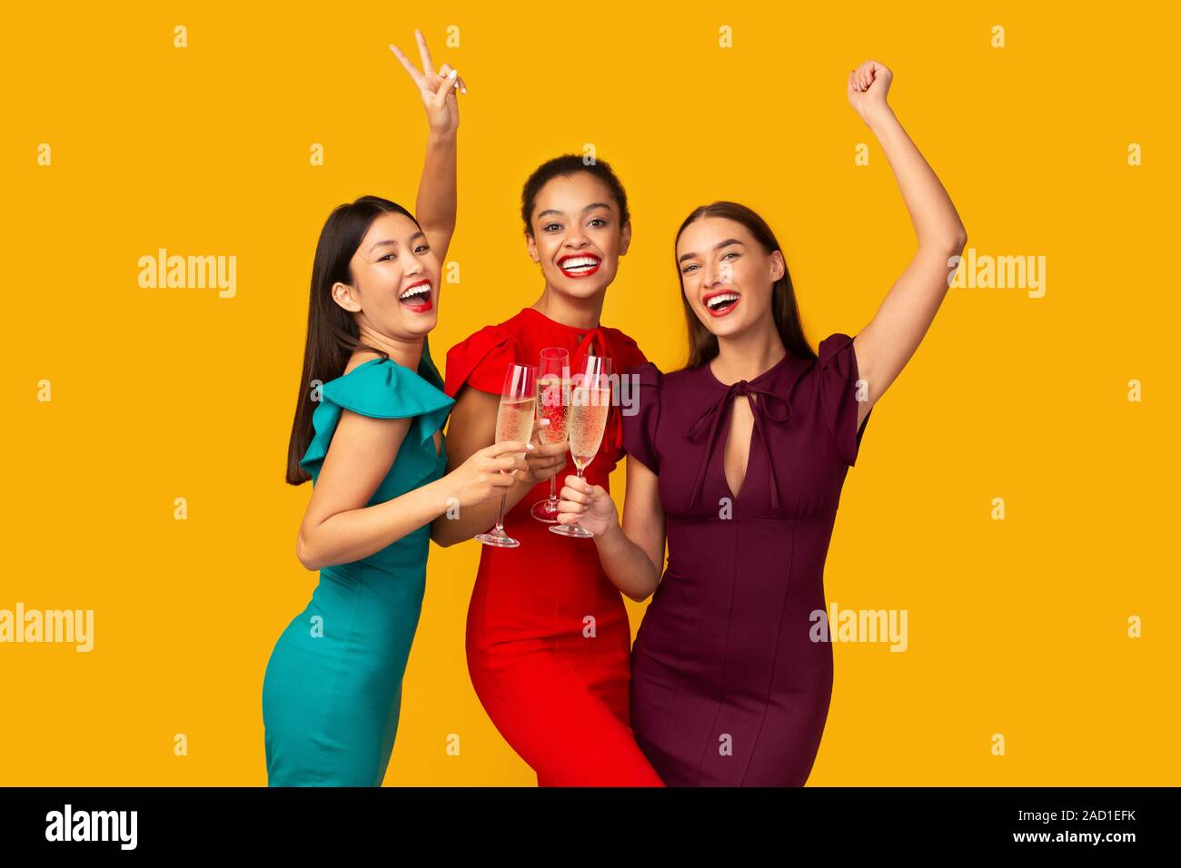 Drei Modelle Anstoßen Spaß auf gelbem Hintergrund Stockfoto