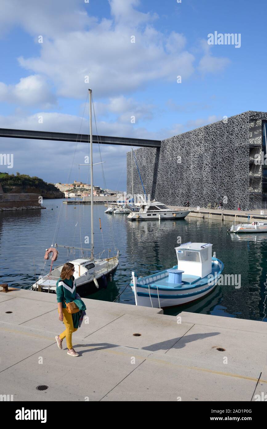 Einzelne Frauen oder junge Frau touristische Entlang Kai von Hafen mit Fischerbooten vor MUCEM Museum Marseille Provence Frankreich Stockfoto