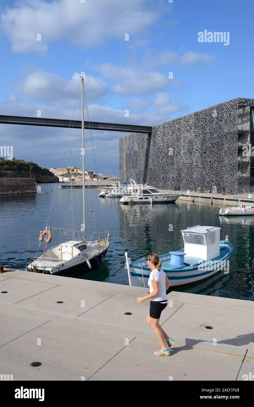 Jogger entlang Kai von Hafen mit Fischerbooten vor MUCEM Museum Marseille Provence Frankreich Stockfoto
