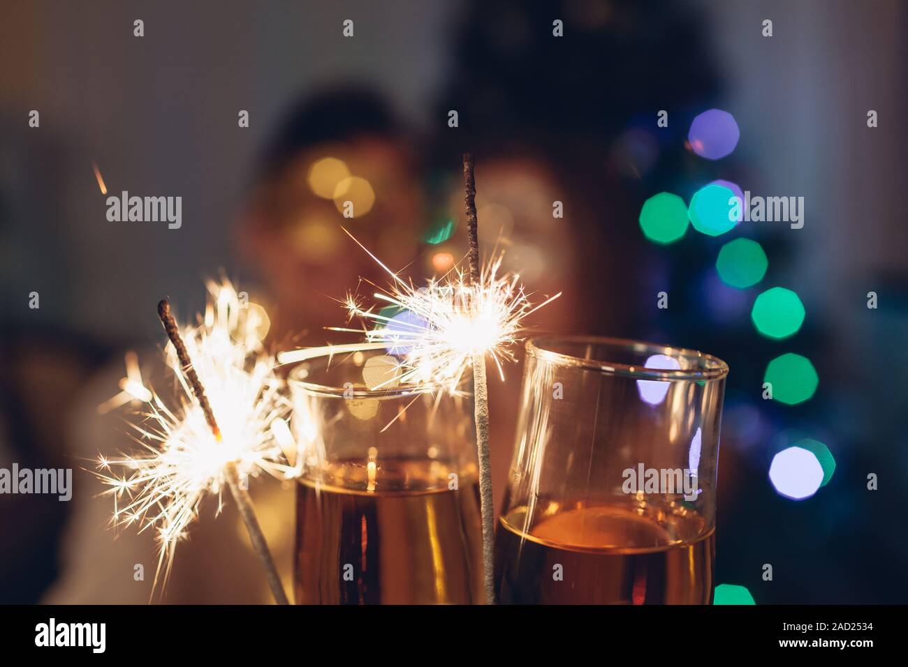 Weihnachten und Neujahr party Konzept. Verliebtes Paar brennende Wunderkerzen beleuchtete Weihnachtsbaum mit Champagner. Stockfoto