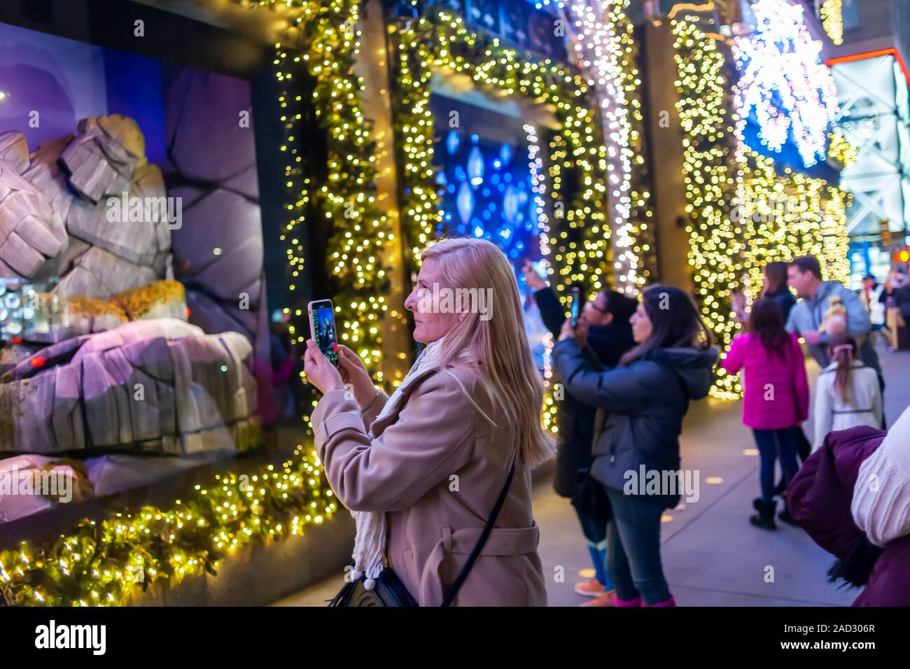 Käufer an der Weihnachten windows von Saks Fifth Avenue an der Fifth Avenue in Midtown Manhattan in New York am Dienstag, 26. November 2019. Dieses Jahr Saks Fifth Avenue hat mit Disney für "Frozen 2 "themed Windows eingegangen. (© Richard B. Levine) Stockfoto