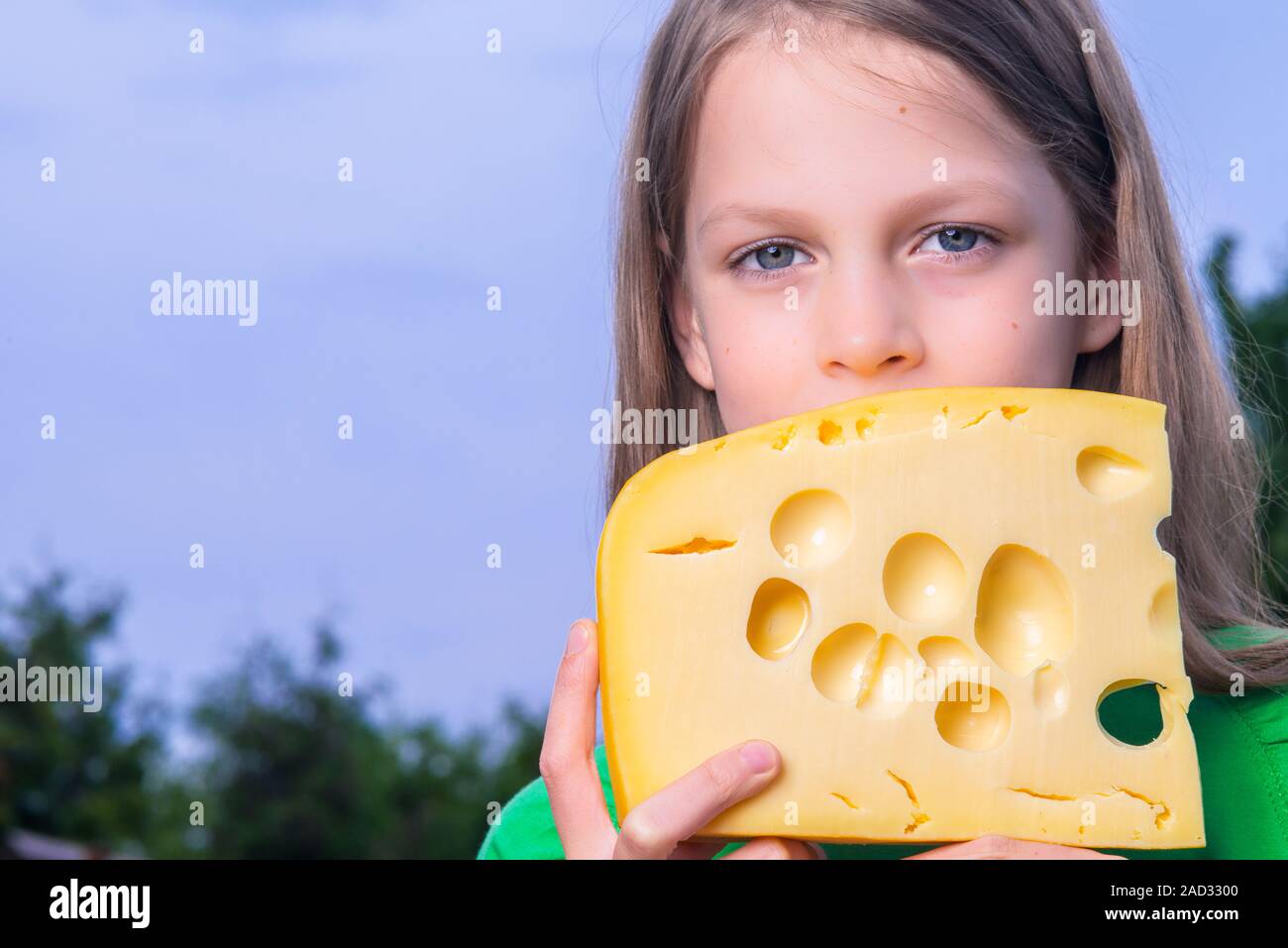 Hübsches Mädchen mit einem großen Stück Käse Stockfoto