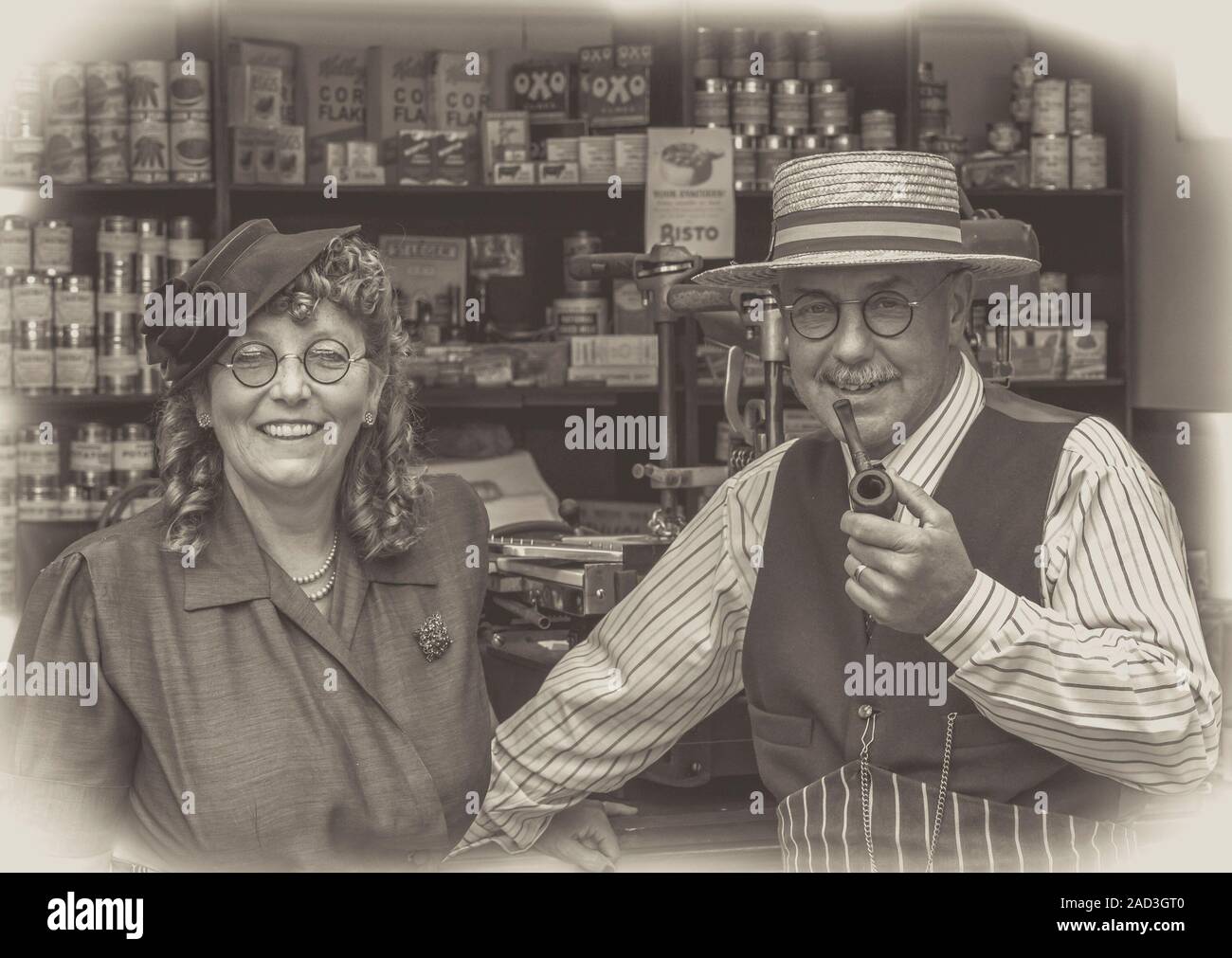 Glückliches Paar, Kleid aus den vierziger Jahren, reenacting Wartime 40s Vintage Lebensmittelgeschäft, Severn Valley Railway WWII Event; Schwarz-Weiß-Foto mit Vignette. Stockfoto