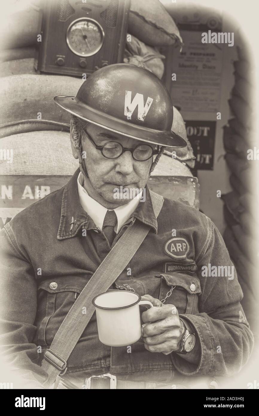 Schwarz-weiß 1940er Mann als Kriegszeit ARP Warden in W Helm (Luftangriff Vorsorge), Severn Valley Railway, UK 1940er WWII Ereignis, durch Luftschutzkeller. Stockfoto