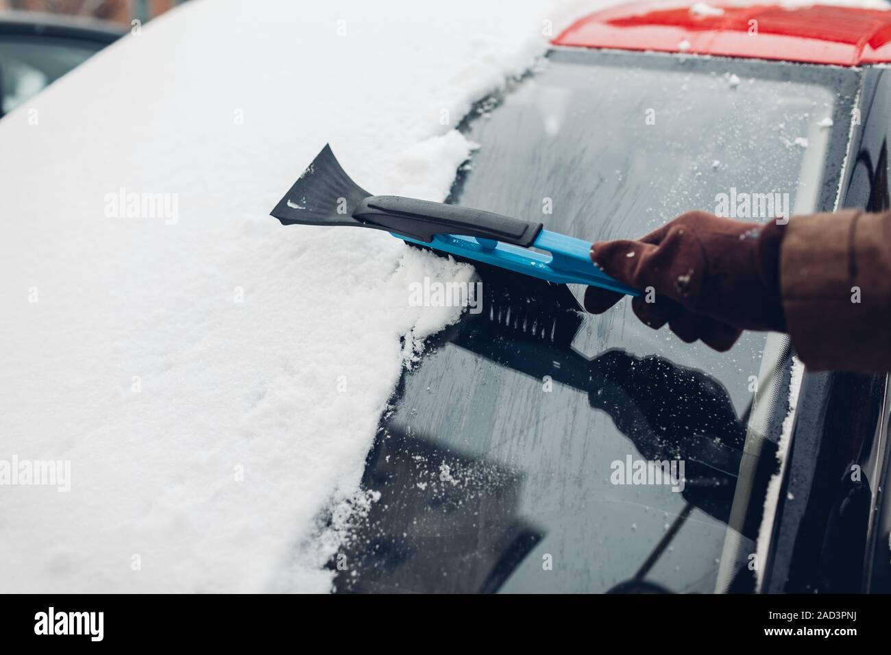 Auto Reinigung von Schnee mit Besen. Man kümmert sich um