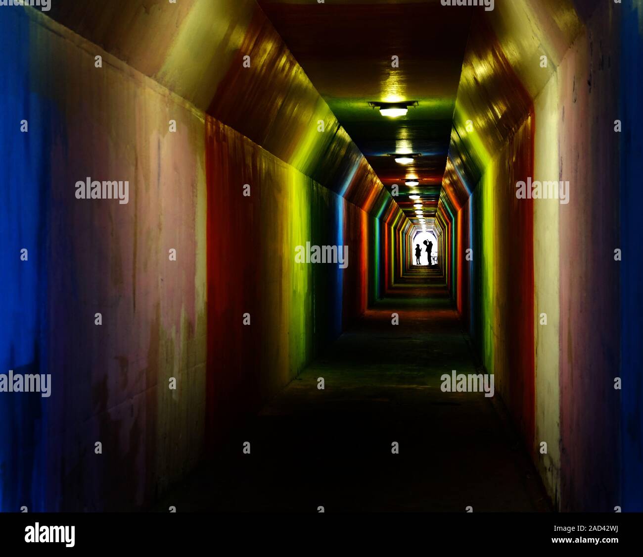 Person Silhouette Silhouette wandern durch bunte Tunnel in Richtung Verwirklichung Stockfoto