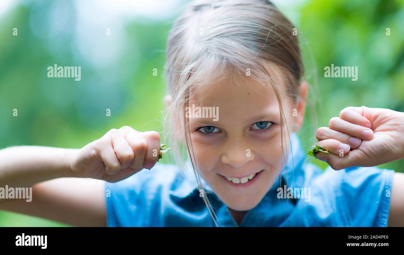 Erstaunt glückliches Mädchen in Blau shirt Spaß im Park Stockfoto