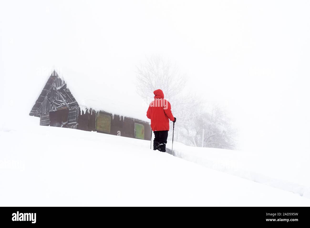 Minimalistischer Winterlandschaft mit Holz- haus und Touristen in der verschneiten Berge. Bewölkt Wetter, Landschaft Fotografie Stockfoto
