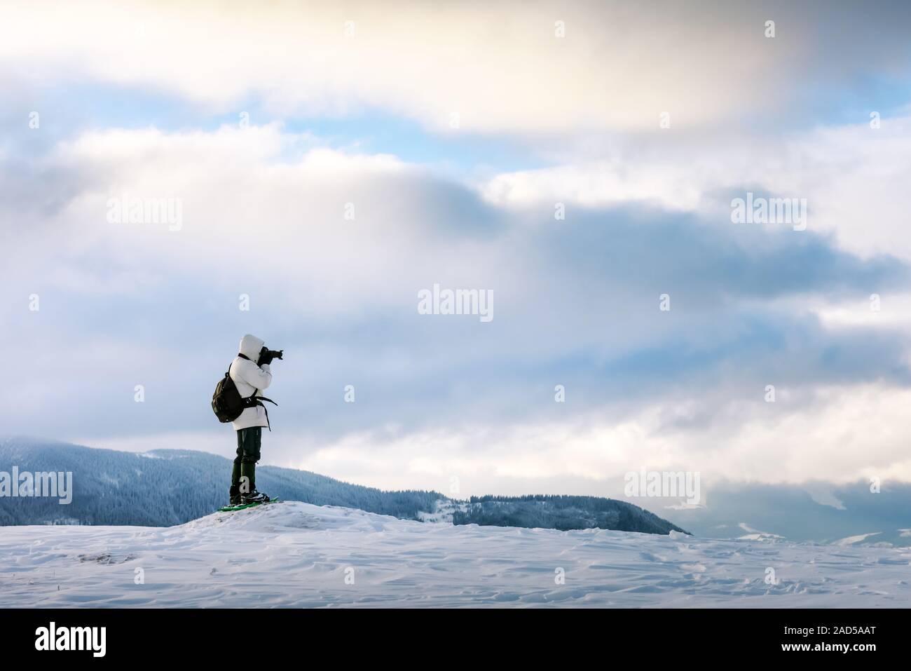 Allein Fotograf in verschneiten Hügeln in Höhe Winter Berge im Sonnenaufgang. Travel Concept. Karpaten. Landschaftsfotografie Stockfoto