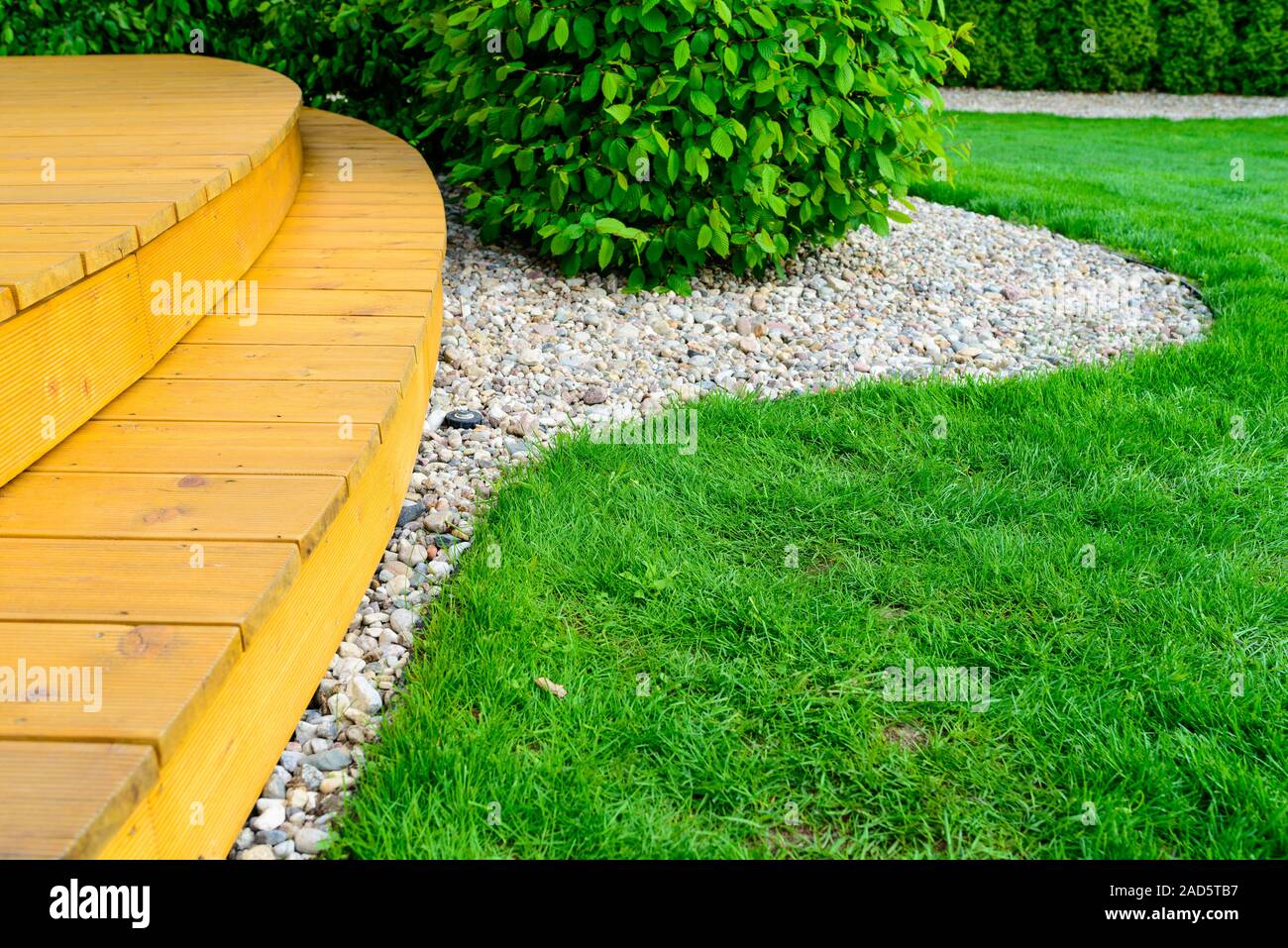 Terrasse im Garten nach Macht Waschen - helle grüne Rasen und kleine weiße Steine Stockfoto