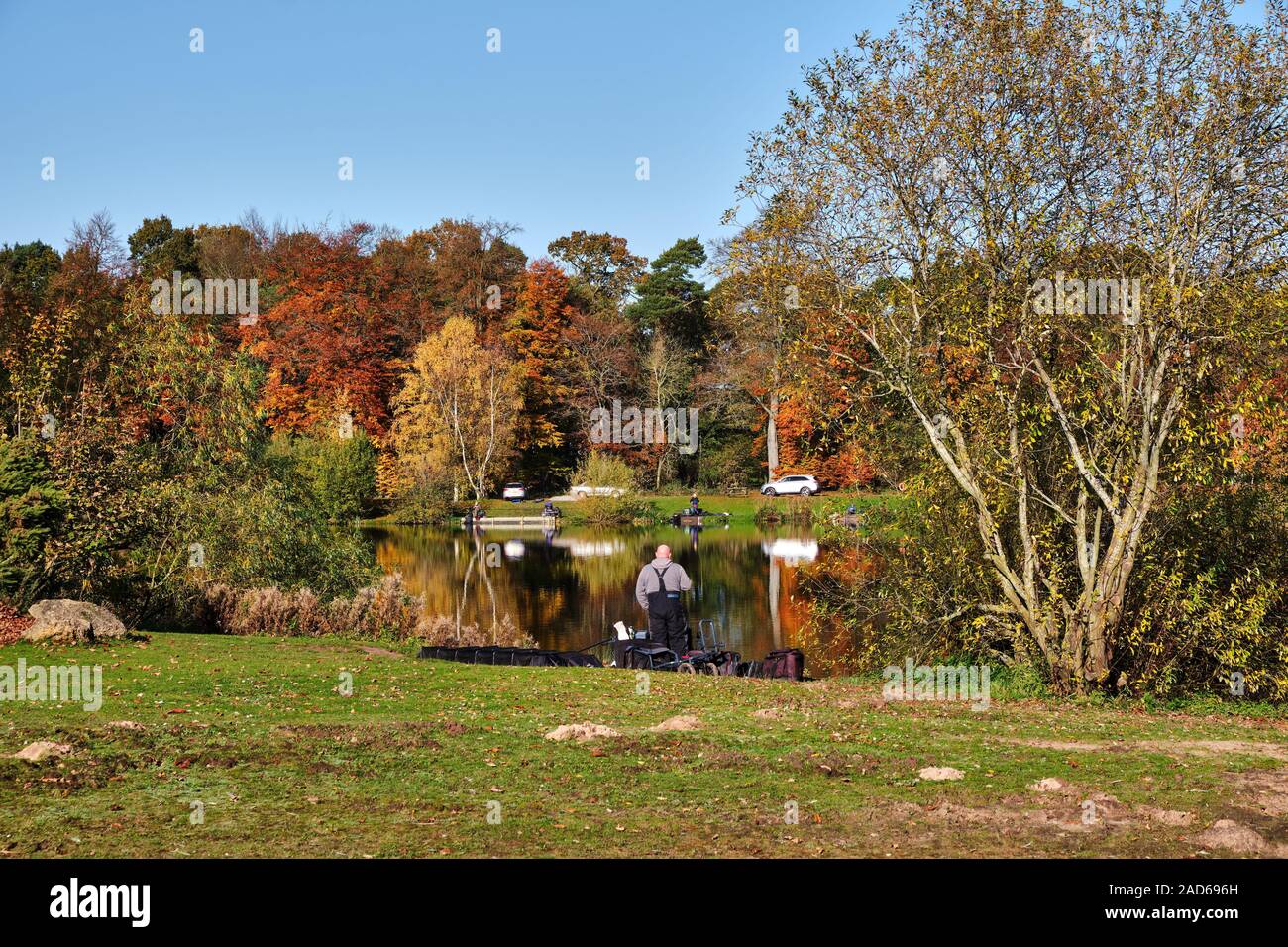 Stillgelegte Kiesgruben bei Woodland Gewässern angeln und Holiday Park Ancaster Lincolnshire, die jetzt als Angeln See mit einem Angler standen am See eingesetzt Stockfoto