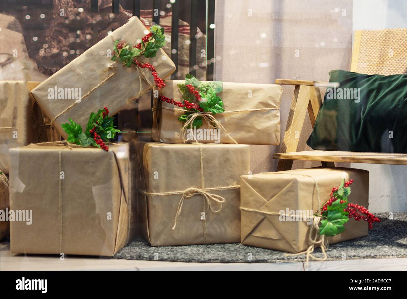 Ein Haufen von großen Weihnachtsgeschenke im Eco wickeln mit Stechpalme Beeren. Weihnachten und neues Jahr Zeit. Wohnzimmer mit vielen Geschenken. Stockfoto