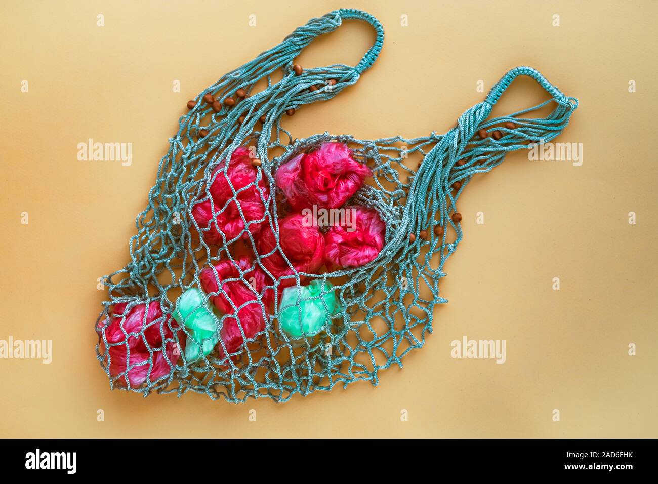 Net Tasche voll von künstlichen Früchten von grünen und roten Plastiktüten. Keine Kunststoff-Konzept. Umweltprobleme. Stockfoto