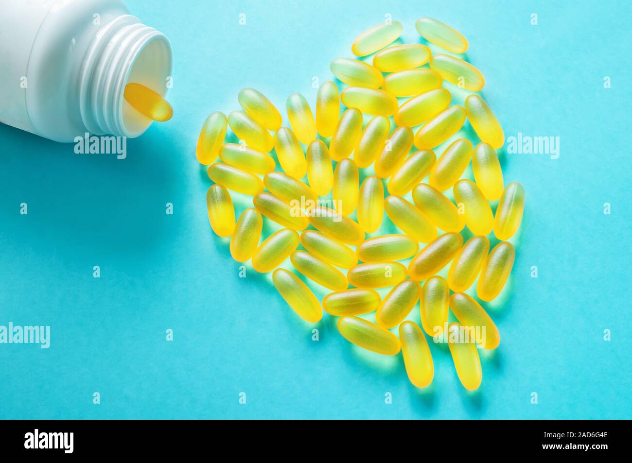 Große medizinische Kapseln und Tabletten - Vitamine und Zusatzstoffe auf blauem Hintergrund liegen in der Form eines Herzens. Kopieren Sie Platz. Close Up. Selektiver Fokus Stockfoto
