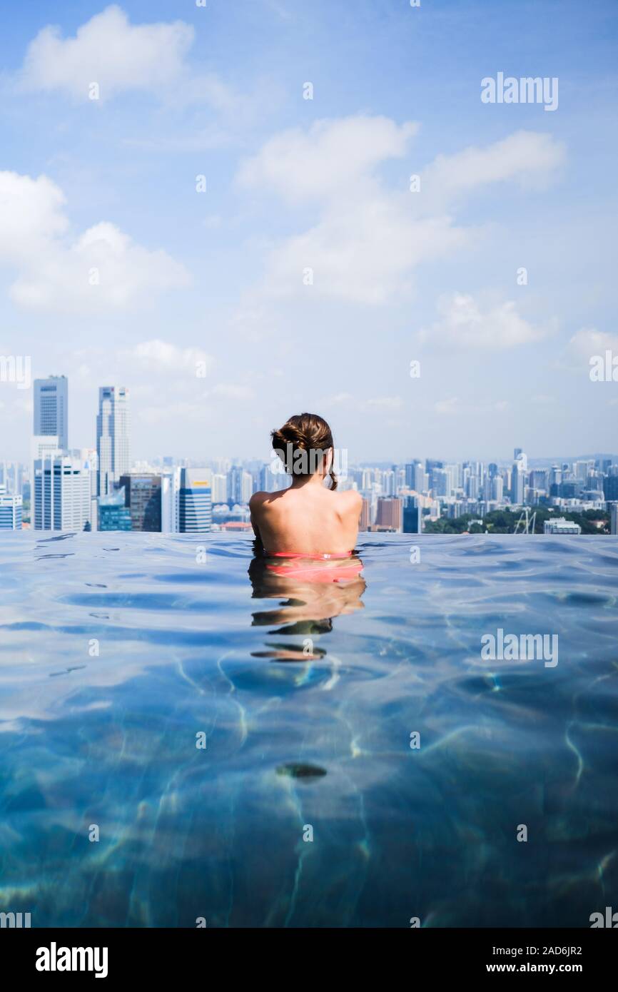 Weiblicher Blick auf die Skyline von Singapur im Infinity-pool an der Marina Bay Sands Stockfoto