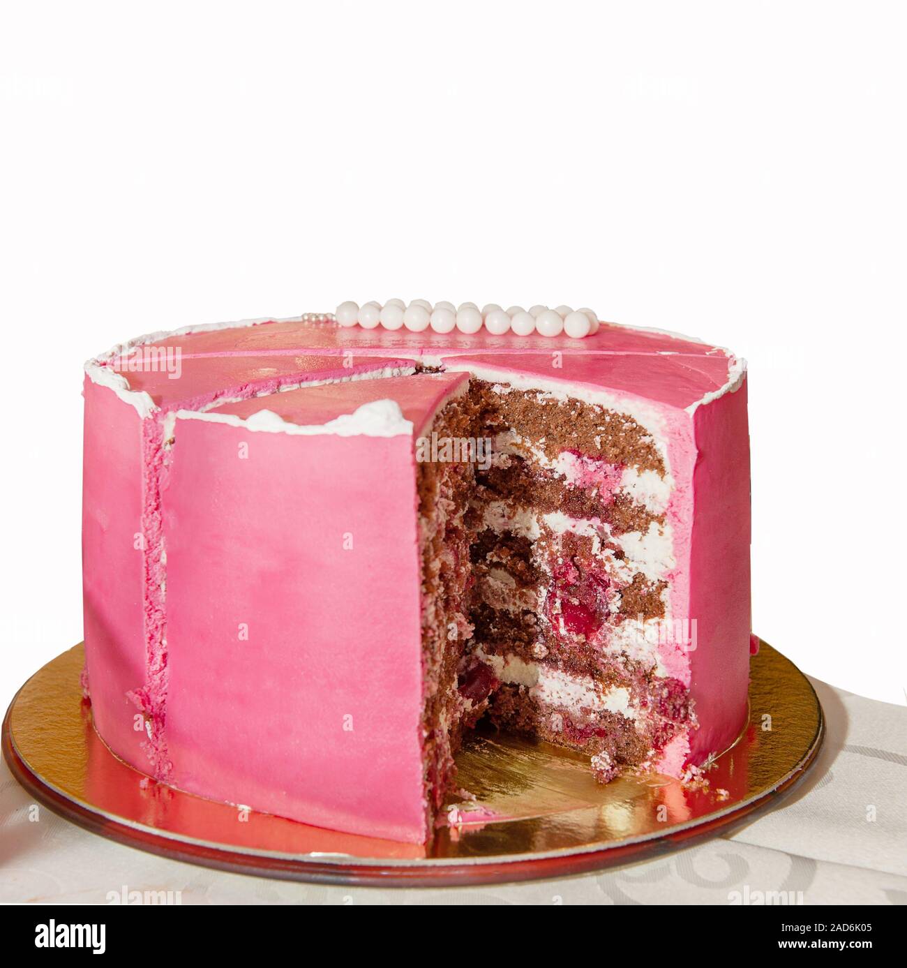 Köstliche rosa Hoch geschichteten Kuchen für die Taufe oder Geburtstag. Schneiden Sie ein Stück Kuchen. Auf weissem Hintergrund. Stockfoto