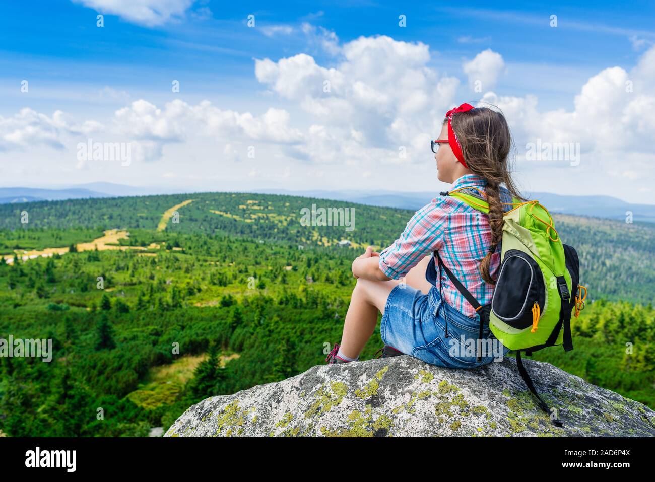 Young Travel Mädchen sitzen auf dem Rock Mountain mit Rucksack, entspannend Stockfoto
