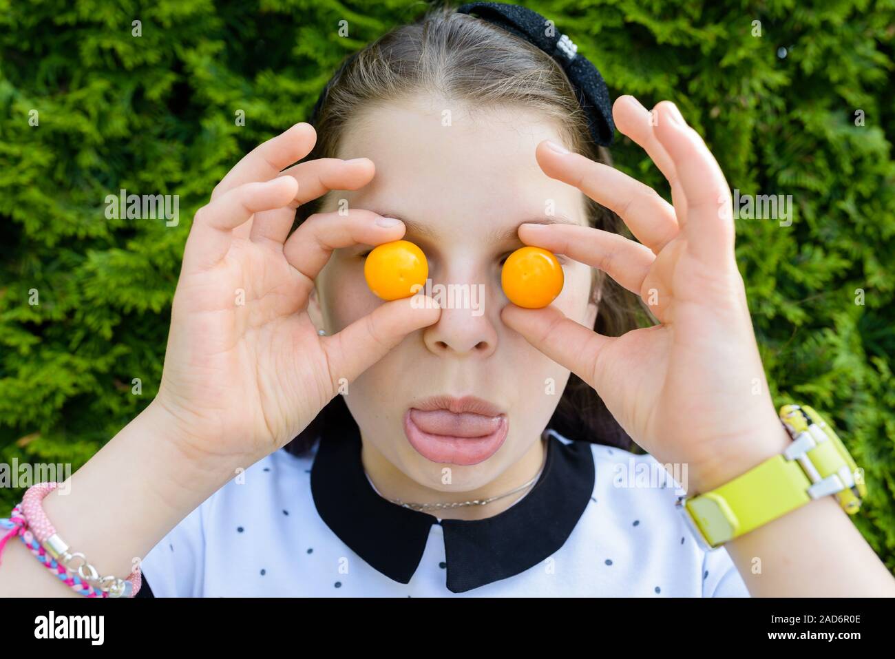 Porträt der jungen, lächelnd, glücklich halten, zeigen kleine Tomaten auf den Augen, Lachen Stockfoto