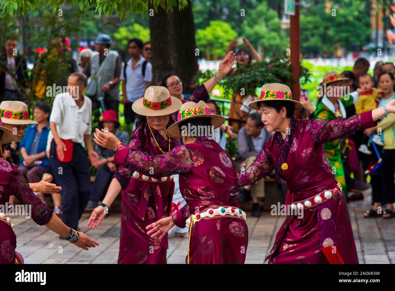 Kunming, China - 12 Juli 2019: Chinesen tanzen auf dem öffentlichen Platz im Park tragen Kleidung, die ethnischen Minderheiten angehören, in Kunming, Provinz Yunnan Stockfoto