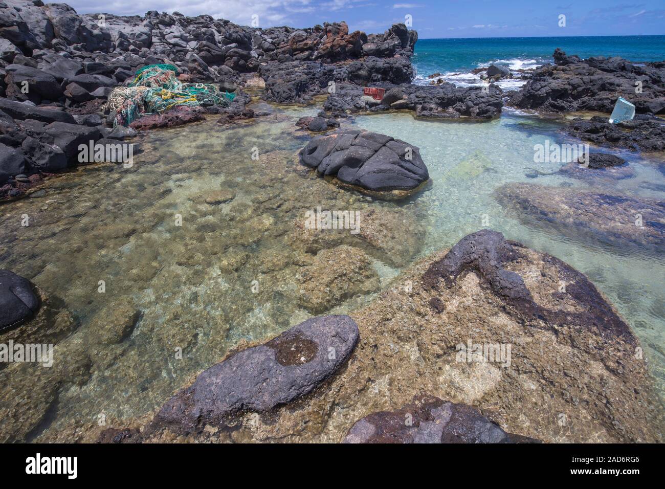 Viel von der Nordseite der Insel Molokai an unzugänglichen. Passatwinde onshore regelmäßig holt mit ihnen Pfähle aus Kunststoff, das gewesen ist, Stockfoto