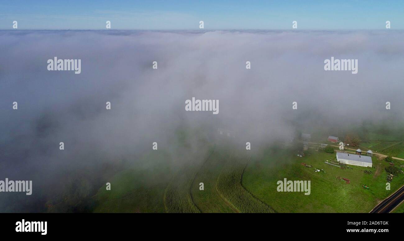 Luftaufnahme des frühen Morgens Nebel mit niedrigen Wolken über die hügelige Landschaft mit Bauernhöfen und ländliche Straßen, Felder von Kulturpflanzen, Hillsboro, Wisconsin, USA. Stockfoto