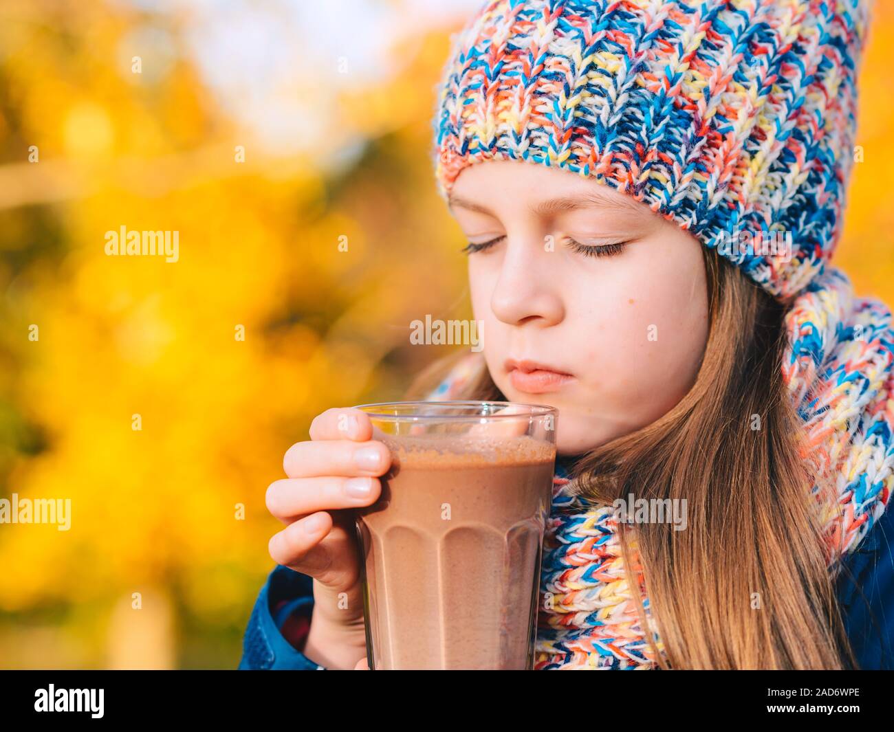 Glücklich lächelnde junge Mädchen trinken Schokolade Milch Stockfoto